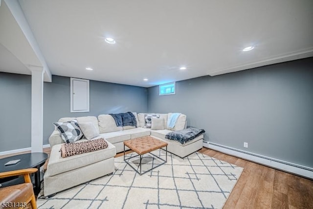 living room with light wood-type flooring and a baseboard heating unit