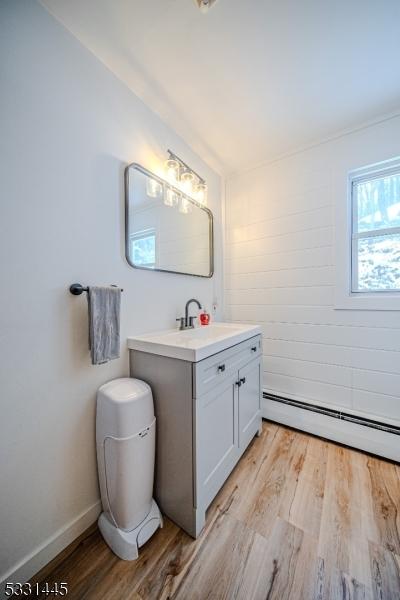 bathroom featuring vanity, a baseboard radiator, and hardwood / wood-style flooring