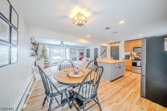 dining area featuring light hardwood / wood-style floors, baseboard heating, and ceiling fan