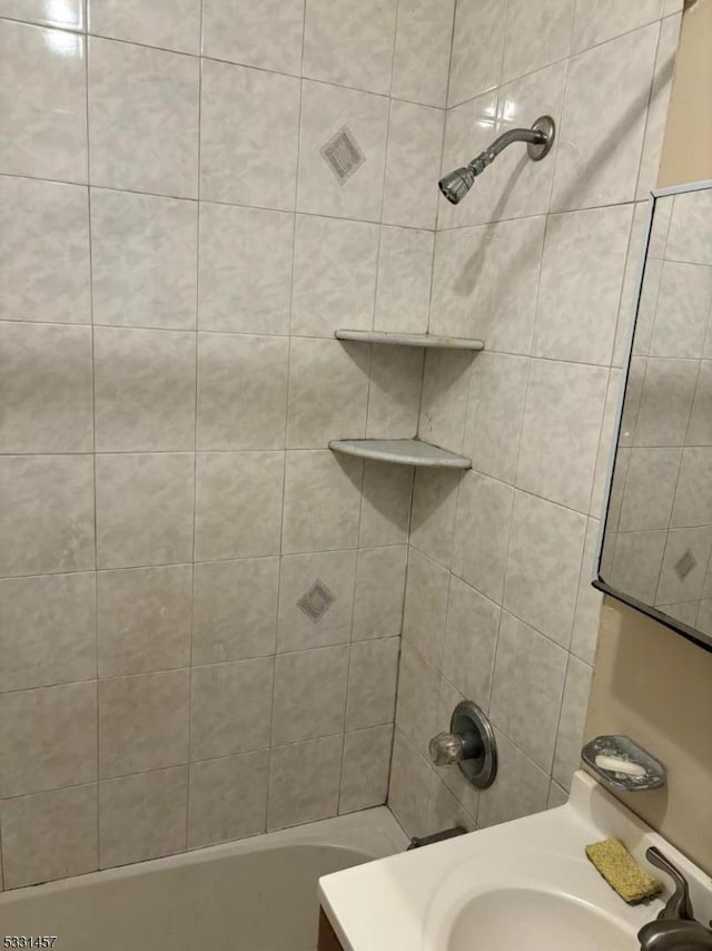 bathroom featuring sink and tiled shower / bath