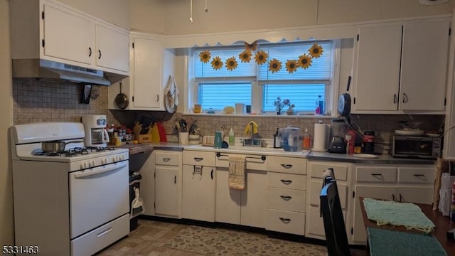 kitchen with white cabinets, tasteful backsplash, and gas range gas stove