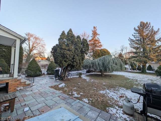 yard covered in snow with a patio area