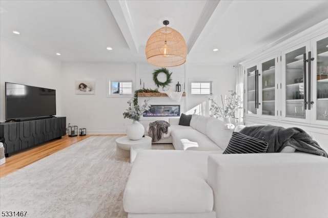 living room featuring hardwood / wood-style flooring, a healthy amount of sunlight, and a large fireplace