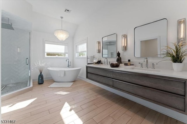 bathroom with vaulted ceiling, hardwood / wood-style floors, vanity, and plus walk in shower