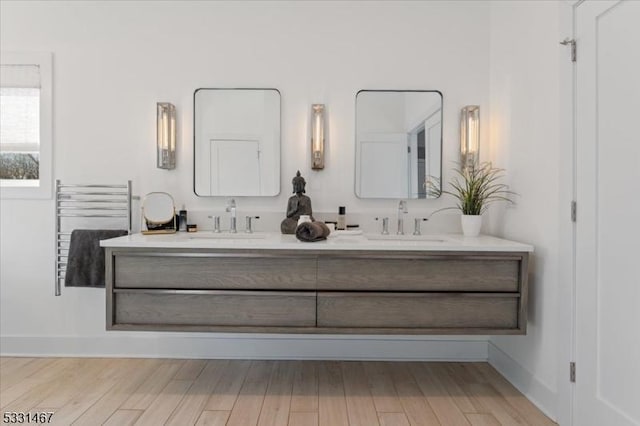 bathroom with vanity, hardwood / wood-style floors, and radiator