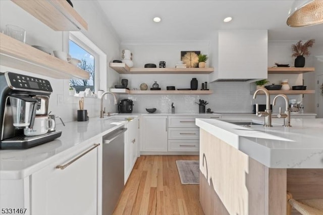 kitchen with sink, white cabinetry, light stone counters, dishwasher, and light hardwood / wood-style floors