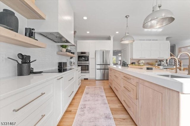 kitchen featuring decorative backsplash, stainless steel appliances, white cabinets, and premium range hood