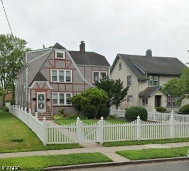 tudor home featuring a front lawn