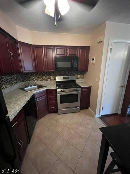 kitchen with black appliances, sink, decorative backsplash, ceiling fan, and light tile patterned floors