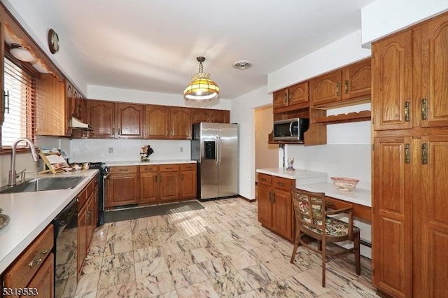 kitchen featuring sink, decorative light fixtures, and appliances with stainless steel finishes