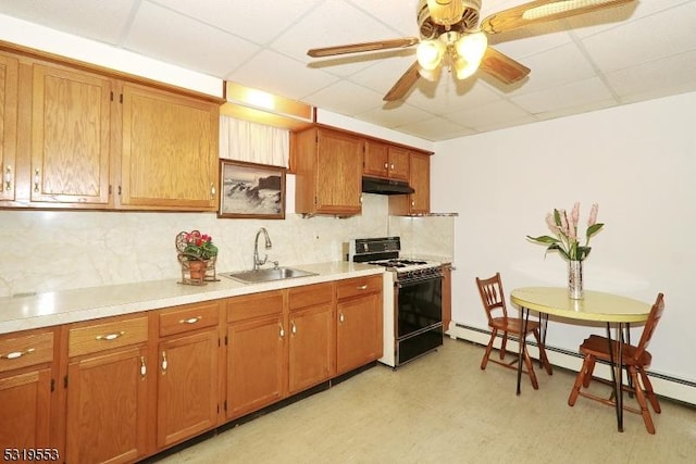 kitchen with a drop ceiling, sink, ceiling fan, a baseboard radiator, and range with gas cooktop