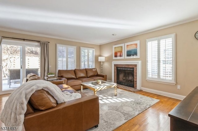 living room with a brick fireplace, light hardwood / wood-style flooring, and crown molding