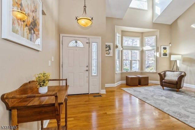 foyer with light wood-type flooring and a high ceiling