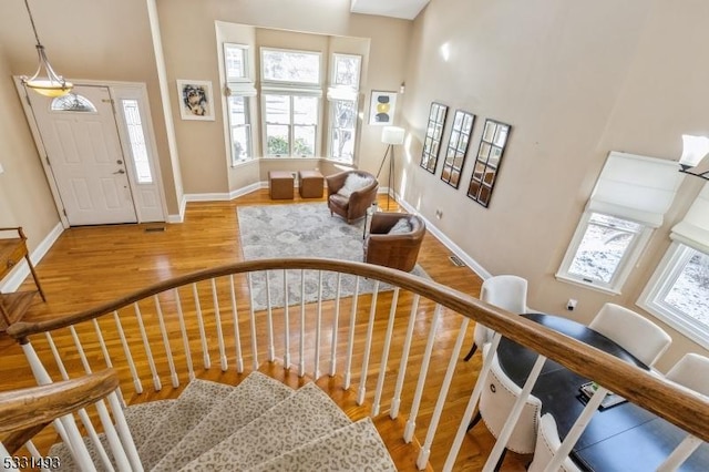 staircase featuring wood-type flooring and a high ceiling