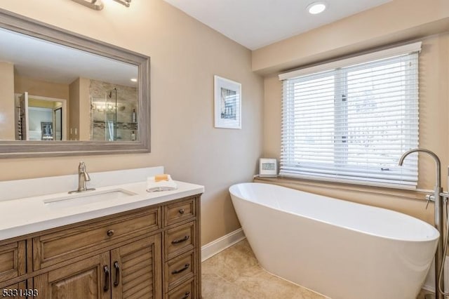 bathroom featuring tile patterned floors, a tub, and vanity