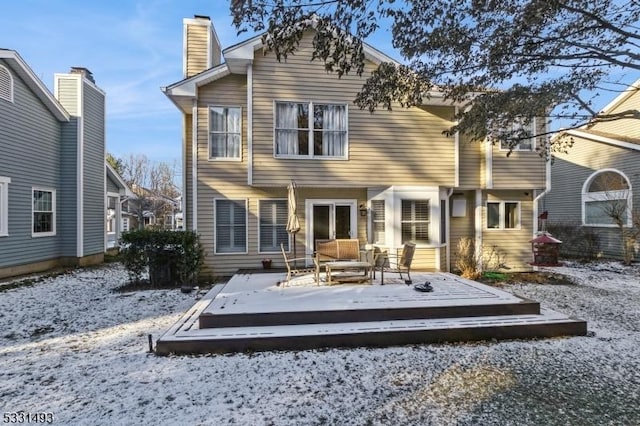 snow covered house with an outdoor hangout area and a deck