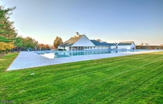 view of swimming pool featuring a yard