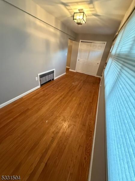 interior space with wood-type flooring and radiator