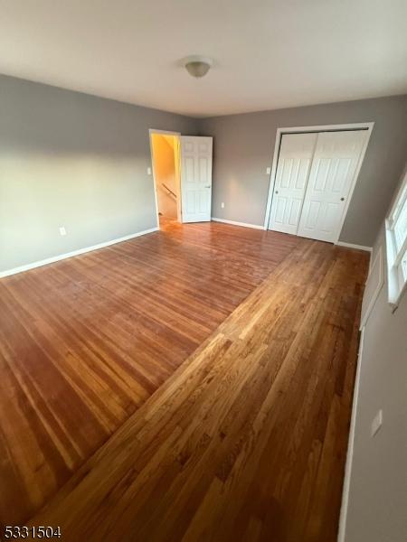 unfurnished bedroom featuring hardwood / wood-style flooring and a closet