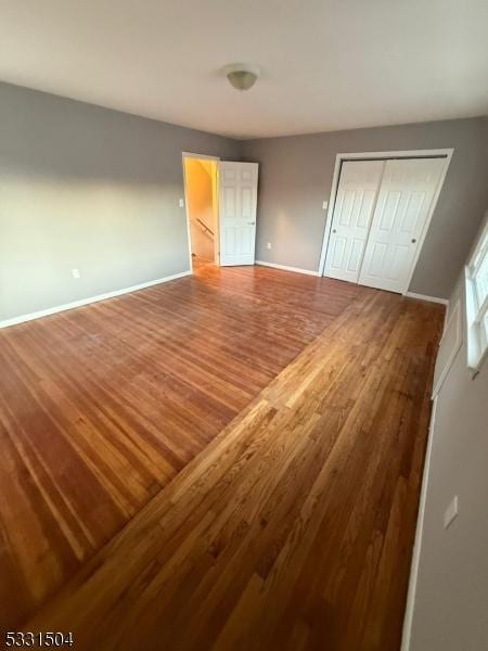 unfurnished bedroom featuring wood-type flooring and a closet