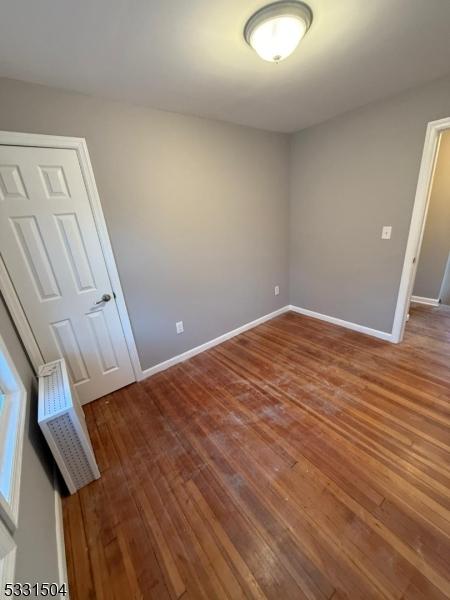 empty room with hardwood / wood-style flooring