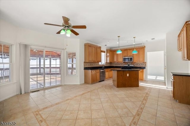 kitchen with a kitchen island, pendant lighting, light tile patterned floors, ceiling fan, and stainless steel appliances