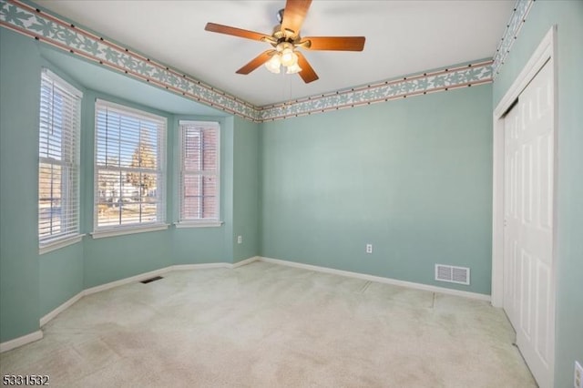 carpeted spare room with ceiling fan