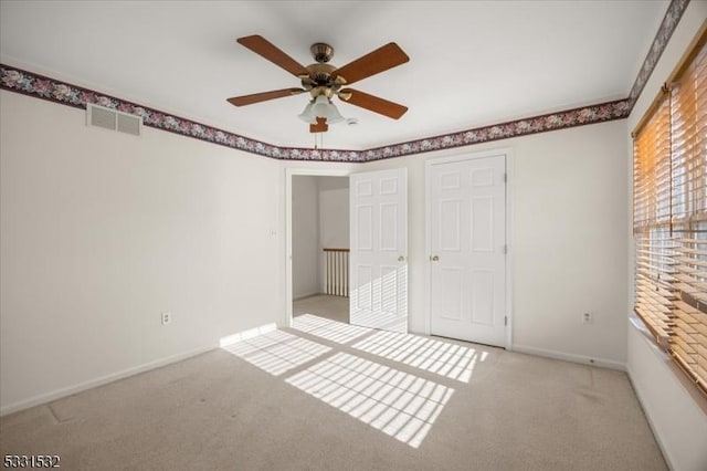 unfurnished bedroom with ceiling fan and light colored carpet