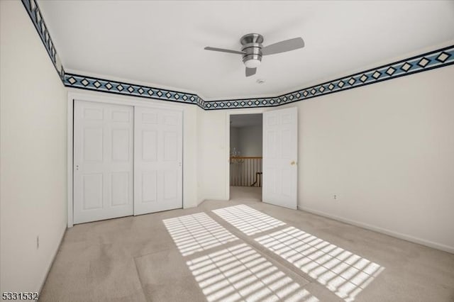 unfurnished bedroom with light colored carpet, a closet, and ceiling fan