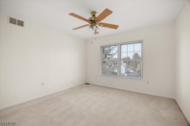 spare room featuring light carpet and ceiling fan