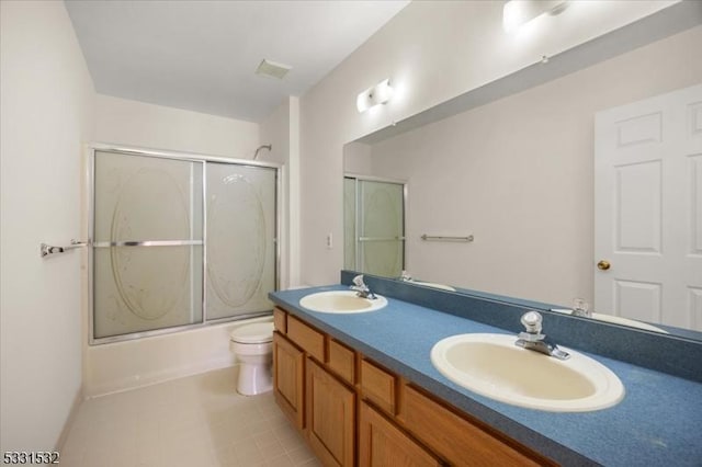 full bathroom featuring tile patterned flooring, vanity, shower / bath combination with glass door, and toilet