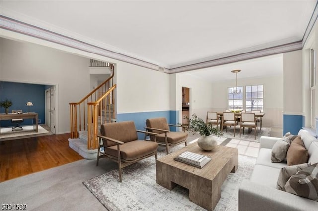 living room featuring an inviting chandelier, ornamental molding, and light hardwood / wood-style flooring