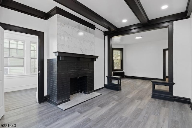 unfurnished living room with tile walls, wood-type flooring, a fireplace, and ornamental molding