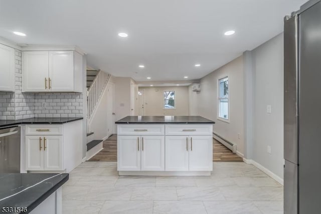 kitchen with white cabinetry, stainless steel appliances, and a baseboard heating unit