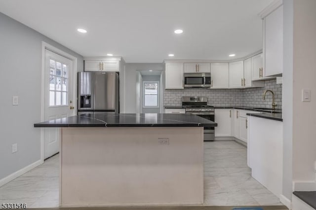 kitchen with white cabinets, a center island, and stainless steel appliances