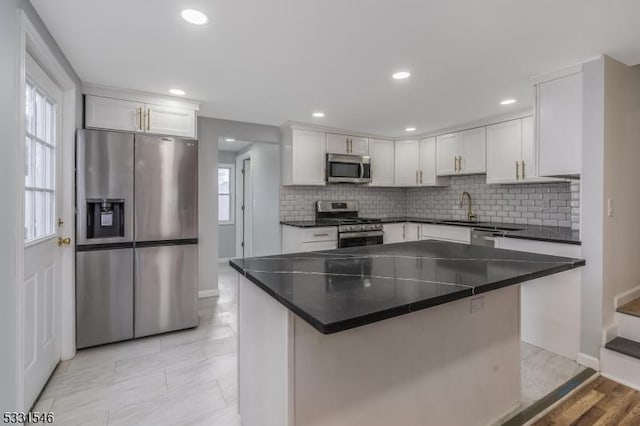 kitchen featuring white cabinetry, sink, appliances with stainless steel finishes, and tasteful backsplash