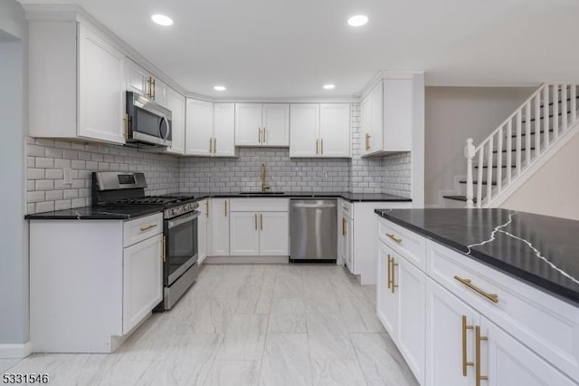 kitchen featuring white cabinets, stainless steel appliances, tasteful backsplash, and sink