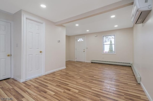 foyer with a wall unit AC, light wood-type flooring, and baseboard heating