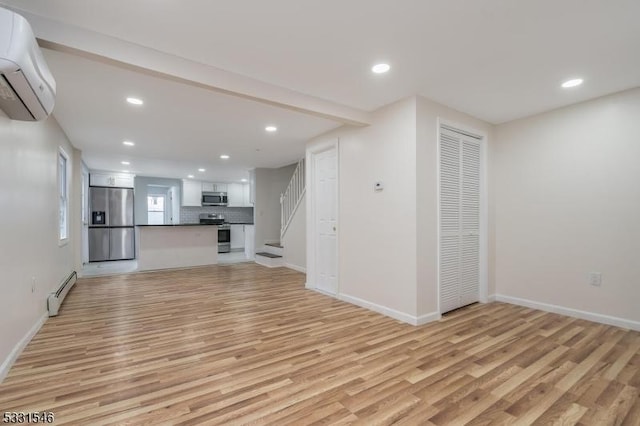 unfurnished living room featuring an AC wall unit, light hardwood / wood-style flooring, and a baseboard radiator