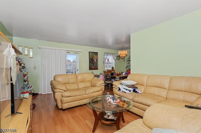 living room with hardwood / wood-style floors and an inviting chandelier