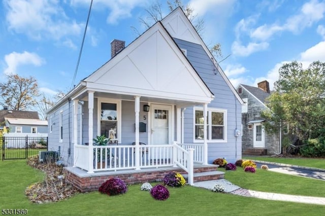 bungalow-style house featuring central AC, a porch, and a front yard