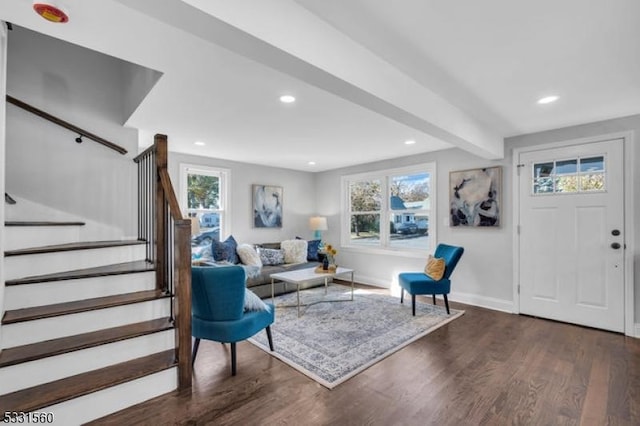 living room with dark hardwood / wood-style floors, a healthy amount of sunlight, and beam ceiling