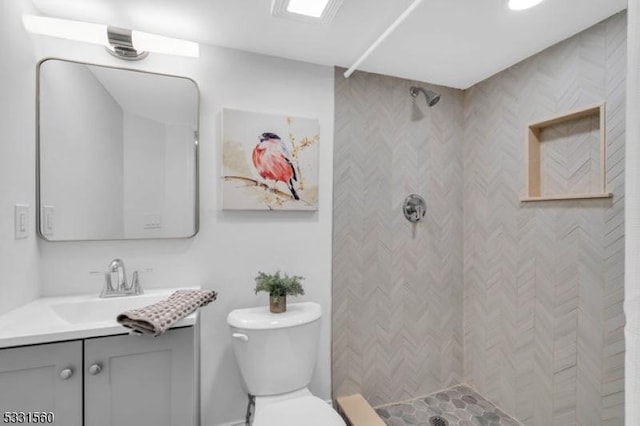 bathroom with vanity, toilet, and a shower