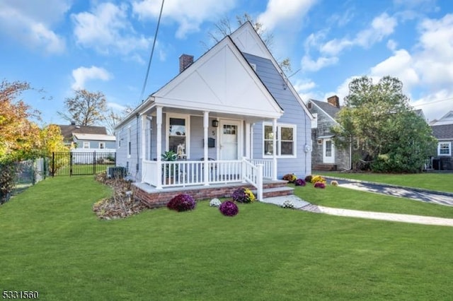 bungalow with central AC unit, a porch, and a front yard