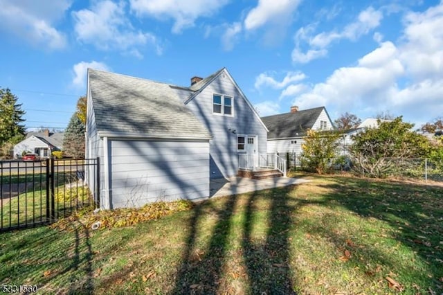 view of side of property featuring a garage and a yard