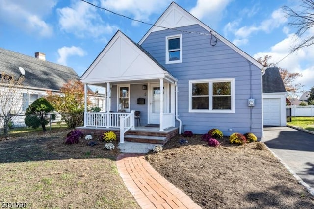 bungalow-style house featuring covered porch, an outbuilding, and a garage