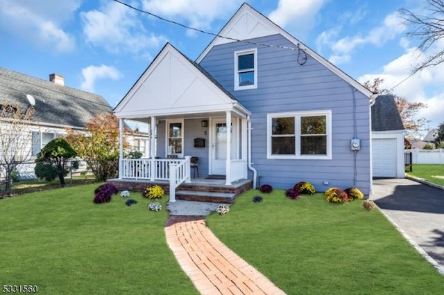 bungalow with an outbuilding, a front lawn, a porch, and a garage