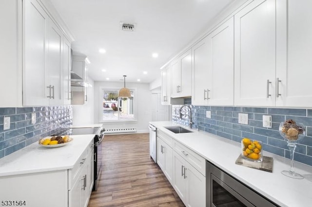 kitchen featuring dark hardwood / wood-style flooring, tasteful backsplash, stainless steel appliances, decorative light fixtures, and white cabinetry