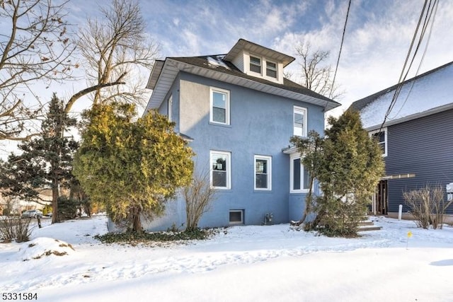 view of snow covered back of property