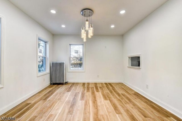 unfurnished room featuring radiator and light hardwood / wood-style floors